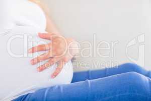 Close up of pregnant woman with one hand on belly