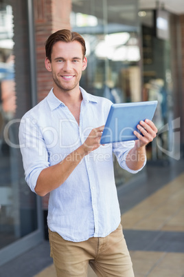 A happy smiling man using his tablet