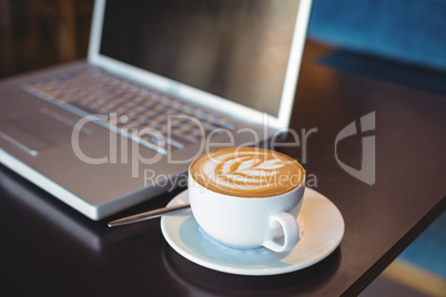 Close-up of laptop and coffee on table