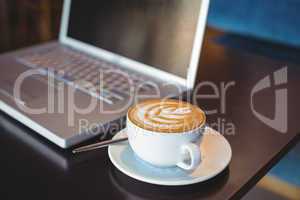 Close-up of laptop and coffee on table