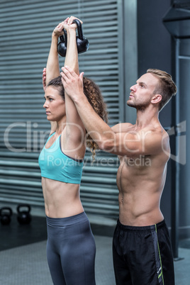 Muscular trainer show how to lift kettlebells