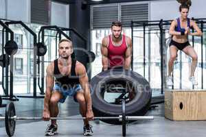 Three muscular athletes lifting and jumping