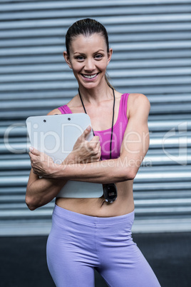 Smiling female coach with a clipboard and stopwatch