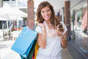 Portrait of smiling woman with shopping bags looking at camera a