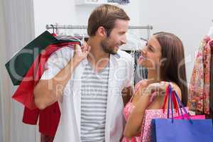 Smiling couple with shopping bags looking at each other