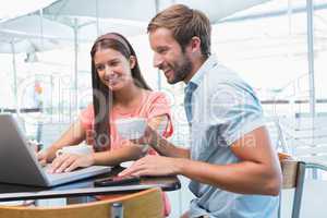 Young happy couple looking at a laptop