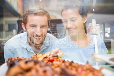 Young happy couple looking at cake