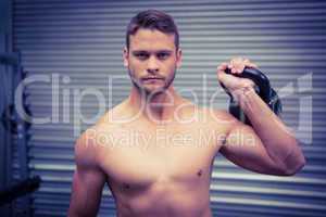 Portrait of muscular man lifting a kettlebell