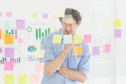 Creative businessman looking at post-it