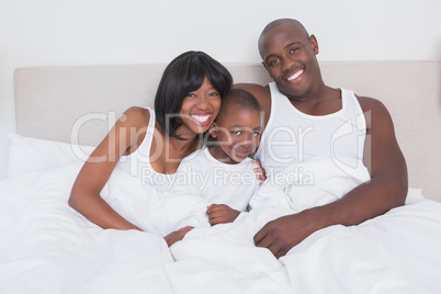 Pretty couple with his son in bed together