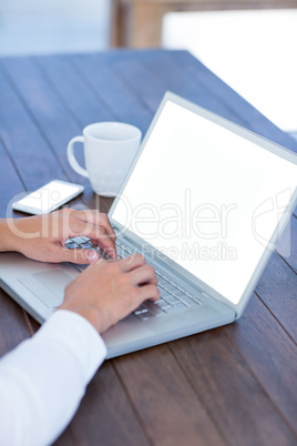 Close up view of a businessman typing on laptop