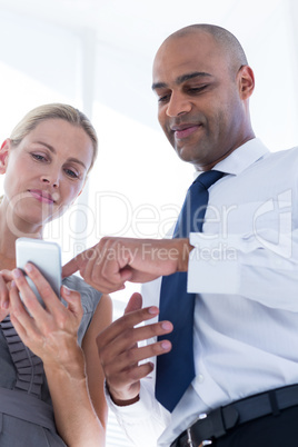 Businesswoman showing her phone to her colleague