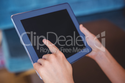 Pretty girl using a small tablet at table