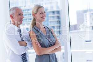 Two smiling business people looking away