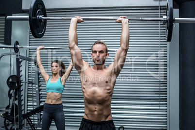 Muscular couple lifting weight together Muscular couple lifting weight together