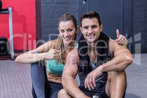Sitting muscular couple looking at the camera
