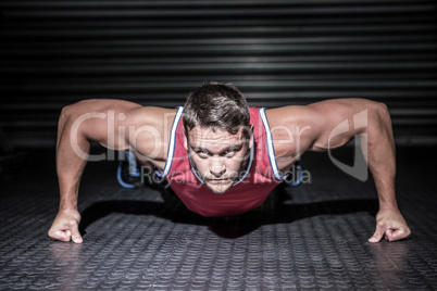 Portrait of muscular man doing push-ups