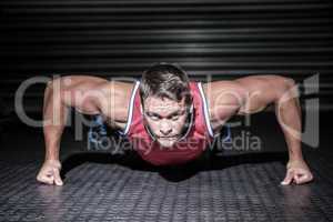 Portrait of muscular man doing push-ups