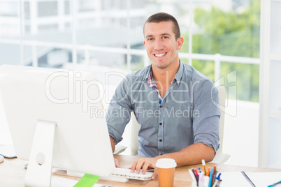 Handsome smiling businessman typing on a computer