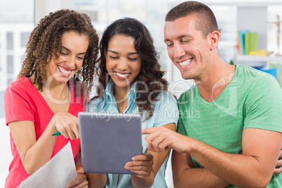 Casual colleagues using digital tablet in office