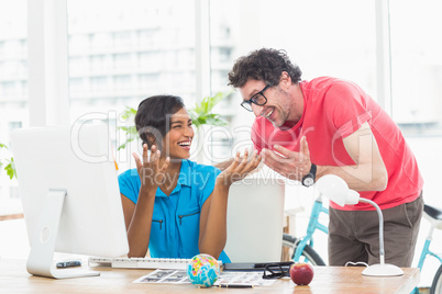 Portrait of cheerful colleagues using computer