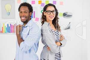 Young smiling business people standing back to back