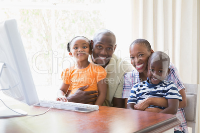 Portrait happy smiling family using computer