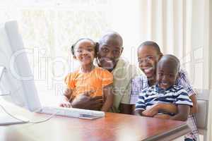 Portrait happy smiling family using computer