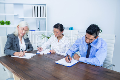 Business people writing on clipboards