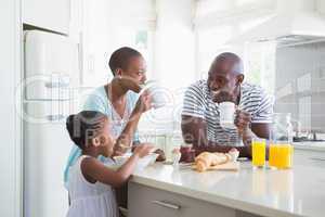 Happy family sitting and taking breakfast