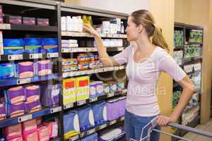 Pretty woman picking product in shelf