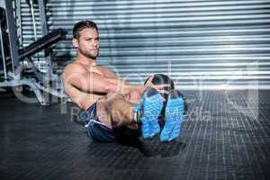 Muscular man doing exercise with medicine ball