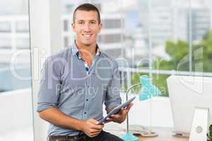 Creative businessman holding a tablet in the office
