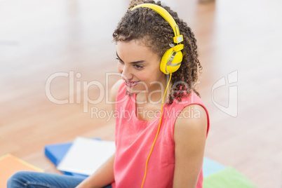 Young creative businesswoman enjoying music