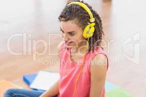 Young creative businesswoman enjoying music