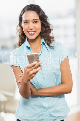 Happy young creative businesswoman texting