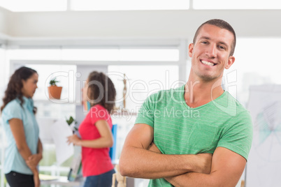 Casual male artist with colleagues in background at office