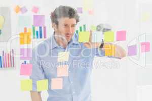 Creative businessman looking at post-it