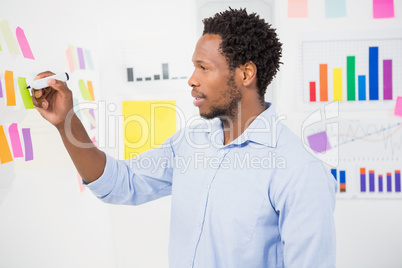 Young creative businessman writing on sticky notes