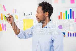 Young creative businessman writing on sticky notes