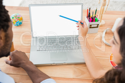 Colleagues brainstorming and pointing laptop screen