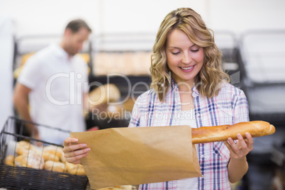 Smiling blonde woman looking at a bread