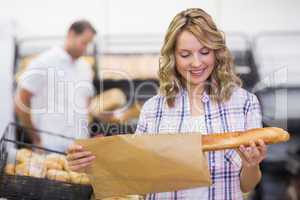 Smiling blonde woman looking at a bread