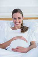 Happy pregnant woman smiling at camera