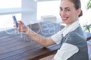 Happy businesswoman using her smartphone