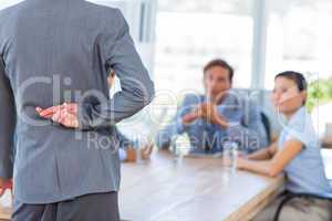 Businesswoman hiding her finger during meeting