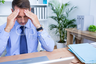 Businessman with severe headache holding his head