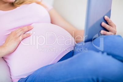 Close up of pregnant woman using tablet