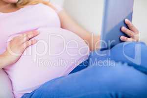 Close up of pregnant woman using tablet