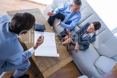 Angry business people speaking together on couch